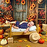Noa joined the competition — help win amazing prizes! baby, infant, child, smiling, portrait, autumn, fall, pumpkins, sunflowers, hay_bales, leaves, wooden_chair, denim_overalls, straw_hat, rustic, harvest, seasonal, studio_photo, cushion, decor