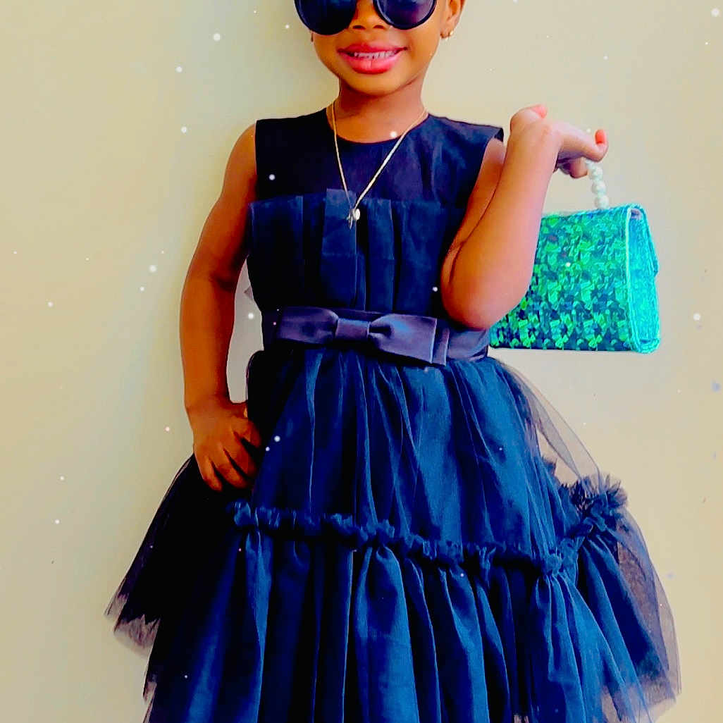 Adriel Theri Singbah joined the competition — help win amazing prizes! accessories, birthday, black_dress, celebration, child, confident, cute, dress, fashion, fun, handbag, happy, headband, indoor, portrait, smile, sneakers, standing, sunglasses, young_girl