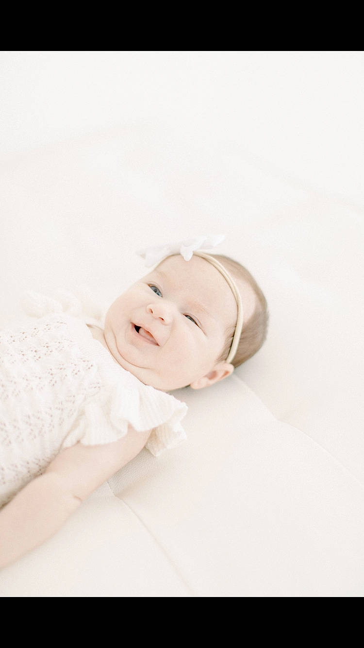 Sharone participe au concours pour gagner de l'argent avec cette photo : baby, baby_toddler_clothing, child, collar, comfort, dress, eyebrow, fashion_accessory, finger, flash_photography, flooring, happy, headgear, linens, pattern, person, sitting, sleeve, smile, toddler