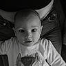 baby, child, infant, face, eyes, sweater, animal_print, black_and_white, portrait, person, clothing, indoor, seated, jeans, adult, lap, cute, expression, closeup, curious