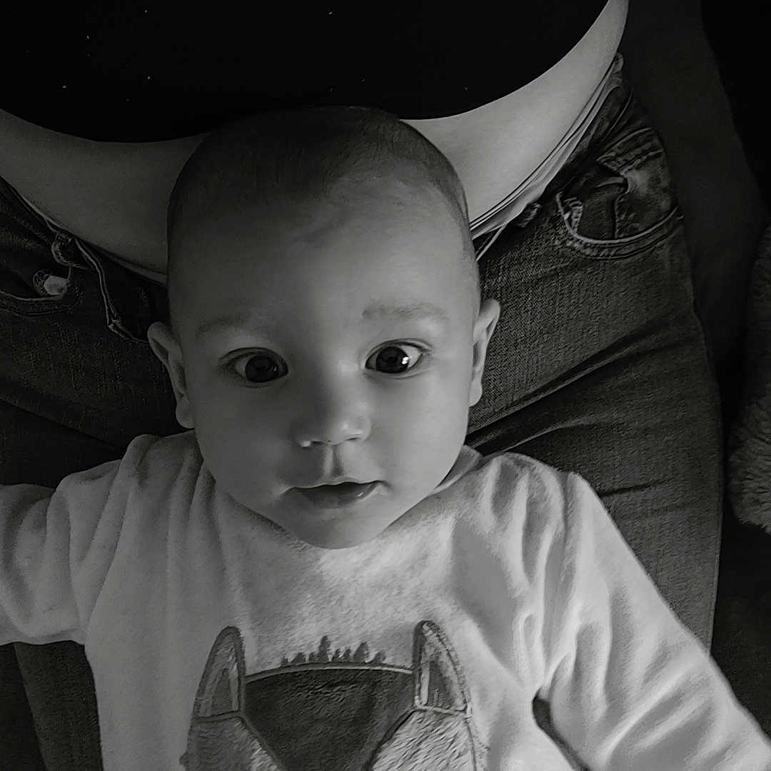 Evan participe au concours pour gagner de l'argent avec cette photo : baby, child, infant, face, eyes, sweater, animal_print, black_and_white, portrait, person, clothing, indoor, seated, jeans, adult, lap, cute, expression, closeup, curious