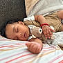 Tadeo is registered to the contest to win money with this photo: baby, sleeping, teddy_bear, blanket, pillow, infant, cozy, cute, child, soft, couch, clothing, red_bracelet, peaceful, rest, indoors, portrait, closeup, hand, relaxation