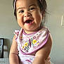 baby, child, smiling, laughing, headband, pink, bib, floral, sitting, table, indoor, cute, happy, person, infant, apparel, hands, face, skin, cheerful