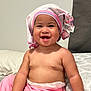 baby, child, smiling, towel, pink_pants, bed, blanket, indoor, cute, happy, skin, person, infant, headwear, funny, portrait, sitting, playful, young, comfort