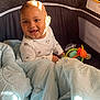 Malachi is registered to the contest to win money with this photo: baby, playpen, blanket, toy, smiling, child, indoors, cozy, light, shadow, happy, colorful, clothing, infant, face, cute, toddler, soft, warm, sitting