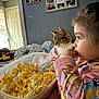 Manny is registered to the contest to win money with this photo: animal, bedroom, blanket, cat, child, closeup, container, curious, family_photos, home, indoor, pajamas, pet, popcorn, relaxed, side_profile, snack, soft_lighting, toddler, wall
