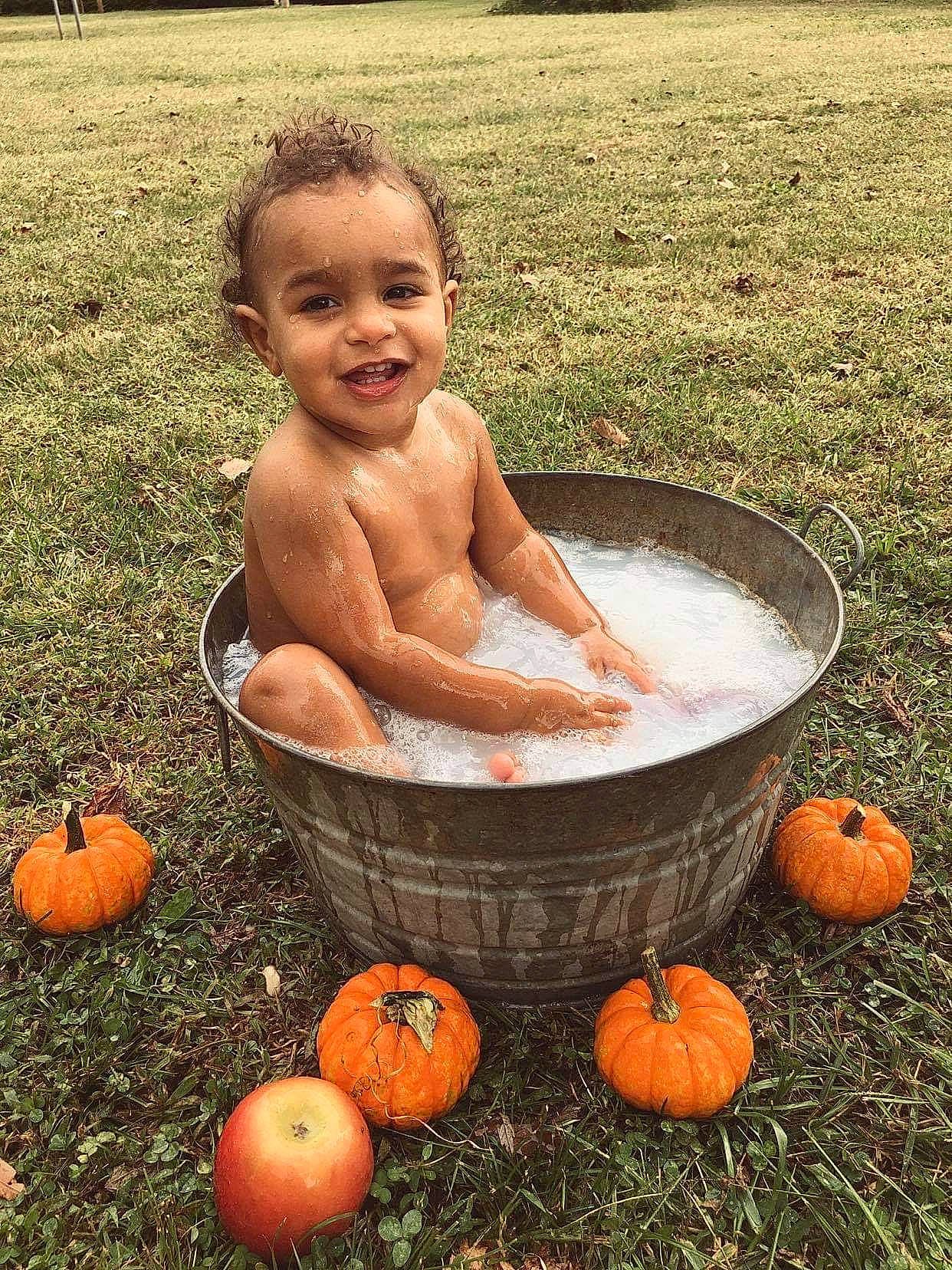 Keaton is registered to the contest to win money with this photo: bathing, calabaza, cucurbita, food, food_group, fruit, gourd, grass, happy, joy, local_food, natural_foods, person, plant, pumpkin, smile, squash, toddler, vegetable, water