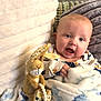 Colby-Reece is registered to the contest to win money with this photo: baby, blanket, child, clothing, comfort, couch, cozy, cute, face, happy, home, indoors, infant, person, pillow, plush, relaxation, smile, soft, toy