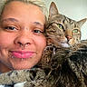 Danni Slay joined the competition — help win amazing prizes! person, cat, tabby_cat, pet, selfie, portrait, face, closeup, green_eyes, whiskers, ears, nose, piercings, smiling, affection, cuddling, collar, indoors, fur, companion