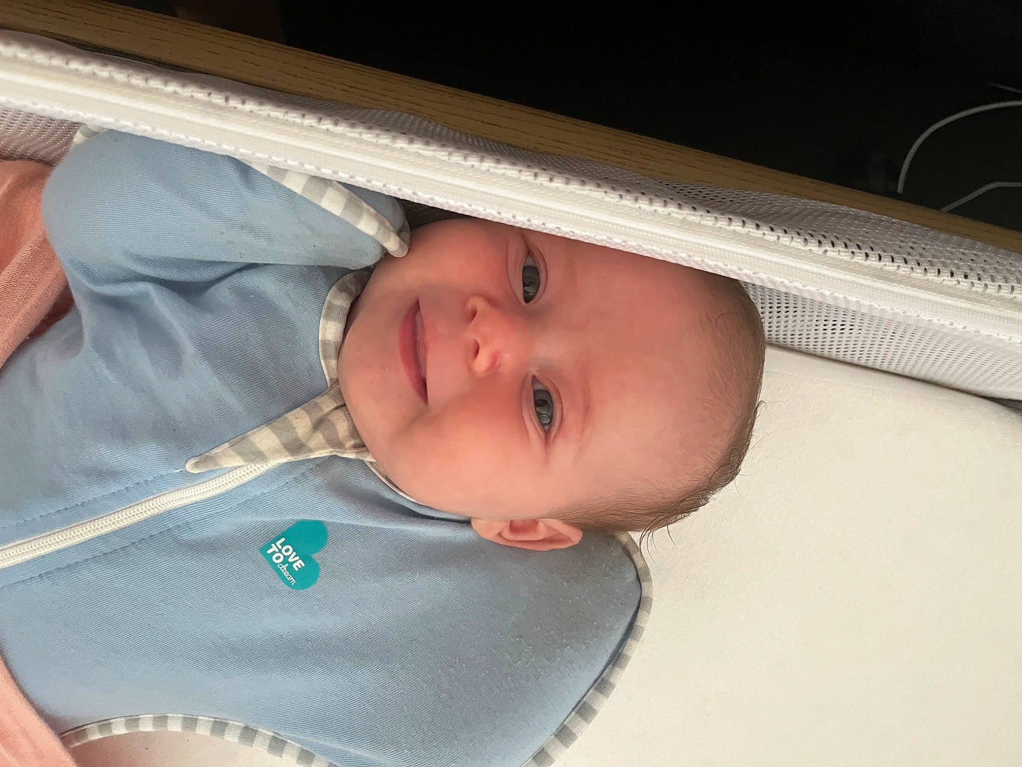 Josephine is registered to the contest to win money with this photo: auto_part, baby, baby_products, baby_safety, baby_toddler_clothing, cheek, child, comfort, electric_blue, eye, eyelash, fashion_accessory, happy, human_body, person, skin, sleeve, smile, toddler, wood