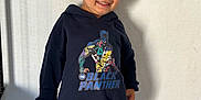 Yanis a rejoint le concours — aidez-le/la à gagner de superbes lots ! black_panther, boy, casual_clothing, child, cute, fashion, floor, happy, hoodie, indoor, jeans, kid, person, playful, portrait, shadow, short_hair, smiling, standing, wall