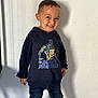 Yanis a rejoint le concours — aidez-le/la à gagner de superbes lots ! child, boy, smiling, standing, hoodie, black_panther, jeans, indoor, casual_clothing, portrait, happy, cute, short_hair, wall, shadow, floor, playful, fashion, person, kid