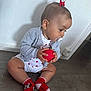 toddler, baby, child, pacifier, red_ball, red_socks, minnie_mouse, cardigan, white_wall, wooden_floor, hair_bow, sitting, curious, indoor, cute, clothing, person, flooring, toy, portrait