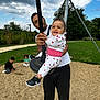 Ayana a rejoint le concours — aidez-le/la à gagner de superbes lots ! adult, casual_clothing, child, clouds, family, fun, grass, gravel, happy, holding, nike_shoes, outdoor, park, play, playground, sky, smile, swing, toddler, trees