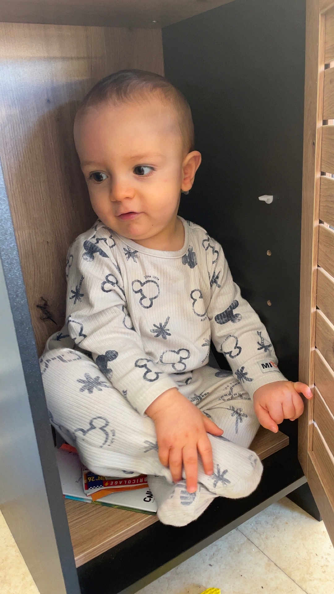 Naoh a rejoint le concours — aidez-le/la à gagner de superbes lots ! toddler, child, pajamas, indoor, wooden_cabinet, curious, sitting, floor, cozy, clothing, person, cute, small_space, exploration, furniture, baby, portrait, hand, footwear, expression