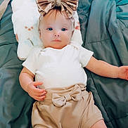 Saylor is registered to the contest to win money with this photo: baby, bed, blanket, bow, child, clothing, cute, fashion, headband, indoors, infant, laying, person, pillow, portrait, relaxed, shorts, sleepwear, soft, toddler