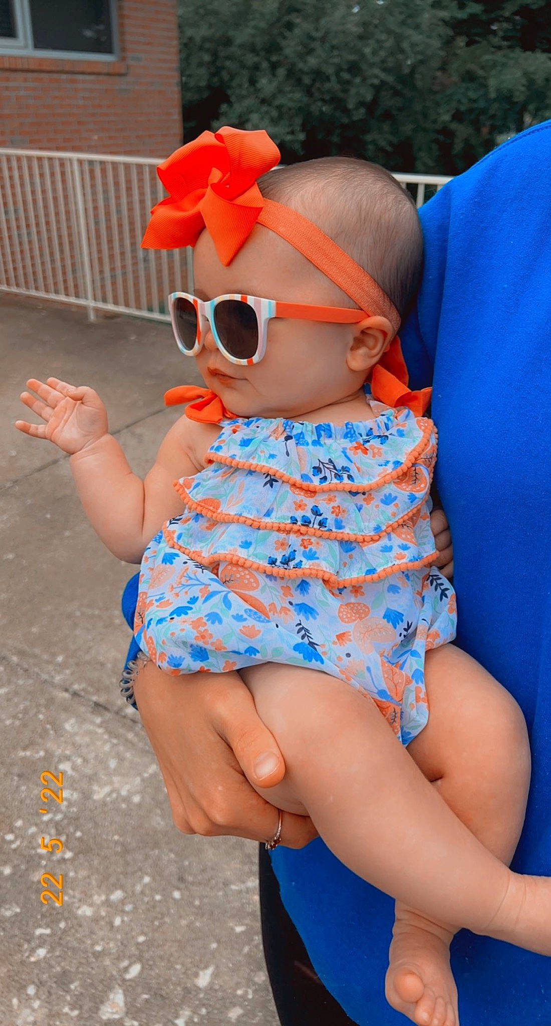 Saylor is registered to the contest to win money with this photo: azure, baby_toddler_clothing, blue, dress, eyewear, finger, glasses, goggles, hand, hat, joint, orange, person, pink, plant, skin, sunglasses, textile, thigh, toddler