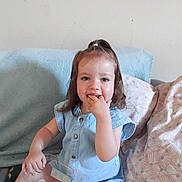 Alma a rejoint le concours — aidez-le/la à gagner de superbes lots ! blue_outfit, casual_clothing, child, couch, fingers_in_mouth, girl, hair_tie, happy, home, indoor, light_skin, person, pillows, plastic_container, playful, relaxed, sitting, smiling, toddler, toys