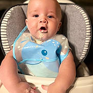 Rowdy is registered to the contest to win money with this photo: baby, high_chair, bib, food, messy, child, infant, cute, face, mouth, hands, blue, plastic, smile, skin, eyes, sitting, feeding, indoor, young