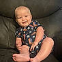 baby, infant, child, smile, sitting, onesie, clothing, couch, leather, foot, hand, face, head, indoors, furniture, cute, happy, skin, person, portrait