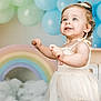 toddler, child, blue_eyes, smiling, white_dress, bow, balloons, rainbow, clouds, pastel_colors, portrait, indoor, celebration, happy, cute, person, baby, curly_hair, background, festive