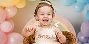 Hadleigh joined the competition — help win amazing prizes! toddler, smiling, birthday, balloons, wicker_chair, dress, pastel_colors, rainbow, happy, child, celebration, curly_hair, blue_eyes, indoor, festive, cute, one_year_old, portrait, party, decorations