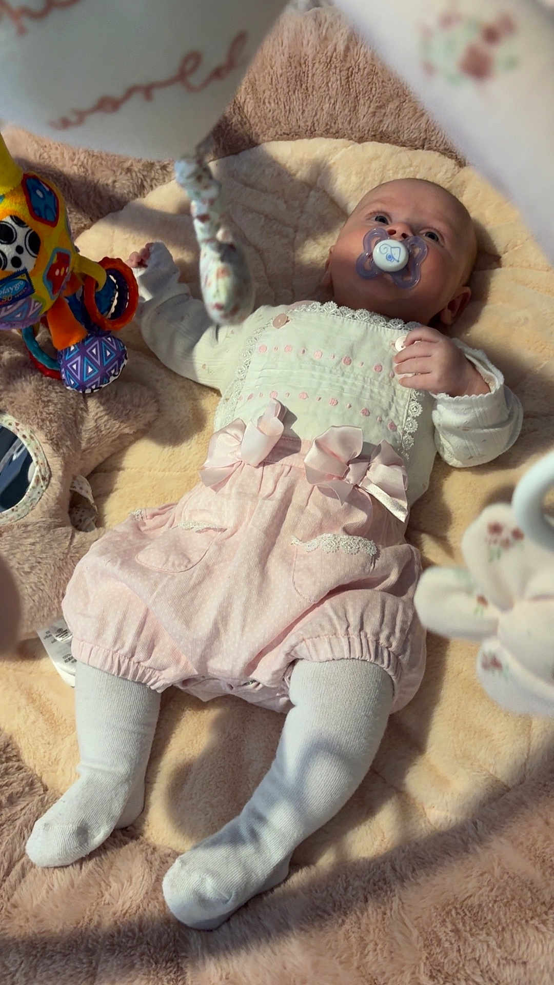 Lilly-Joan is registered to the contest to win money with this photo: baby, blanket, child, clothing, comfort, cute, face, indoor, infant, lying_down, newborn, pacifier, pink, play_area, plush, portrait, soft_toy, tights, toy, white