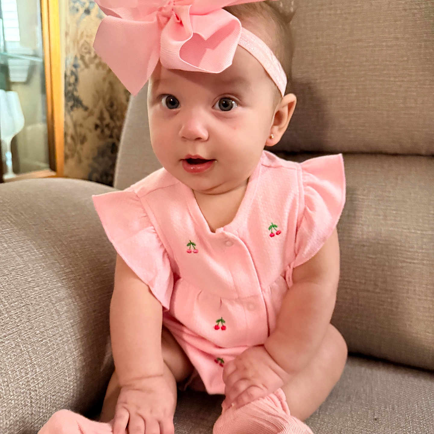 Alani is registered to the contest to win money with this photo: baby, child, infant, sitting, couch, portrait, pink, bow, headband, dress, socks, cherries, smiling, indoors, home, furniture, face, eyes, daylight, cute