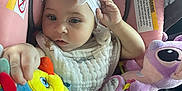 Avory is registered to the contest to win money with this photo: baby, child, car_seat, pink, headband, bow, plush_toy, colorful, infant, seatbelt, cute, soft_toys, indoors, person, skin, hand, clothing, portrait, young, seat
