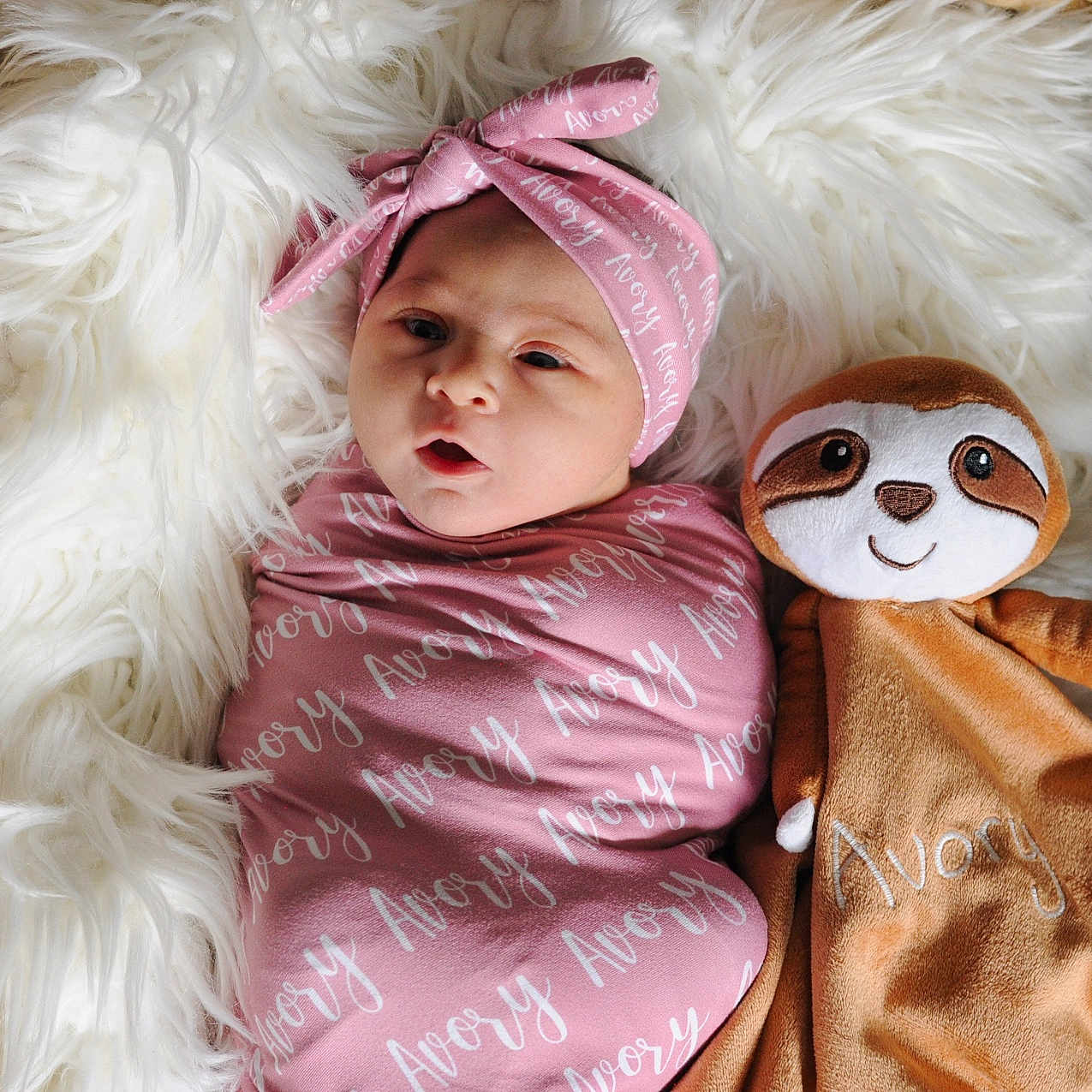Avory joined the competition — help win amazing prizes! adorable, baby, basket, blanket, child, cozy, cushion, cute, fluffy, headband, infant, lying_down, pink, plush_toy, portrait, sloth, soft_toy, swaddle, wooden_floor, wrapped