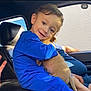 animal, blue_clothing, car_interior, casual, child, cute, family, fur, happy, hugging, indoor, person, pet, portrait, puppy, seat, smiling, sunlight, window, young