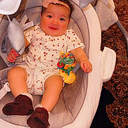 Aylin joined the competition — help win amazing prizes! baby, infant, child, baby_rocker, toy, headband, clothing, footwear, carpet, indoor, smiling, cute, comfort, fabric, seat, childrens_toy, person, happy, home, play