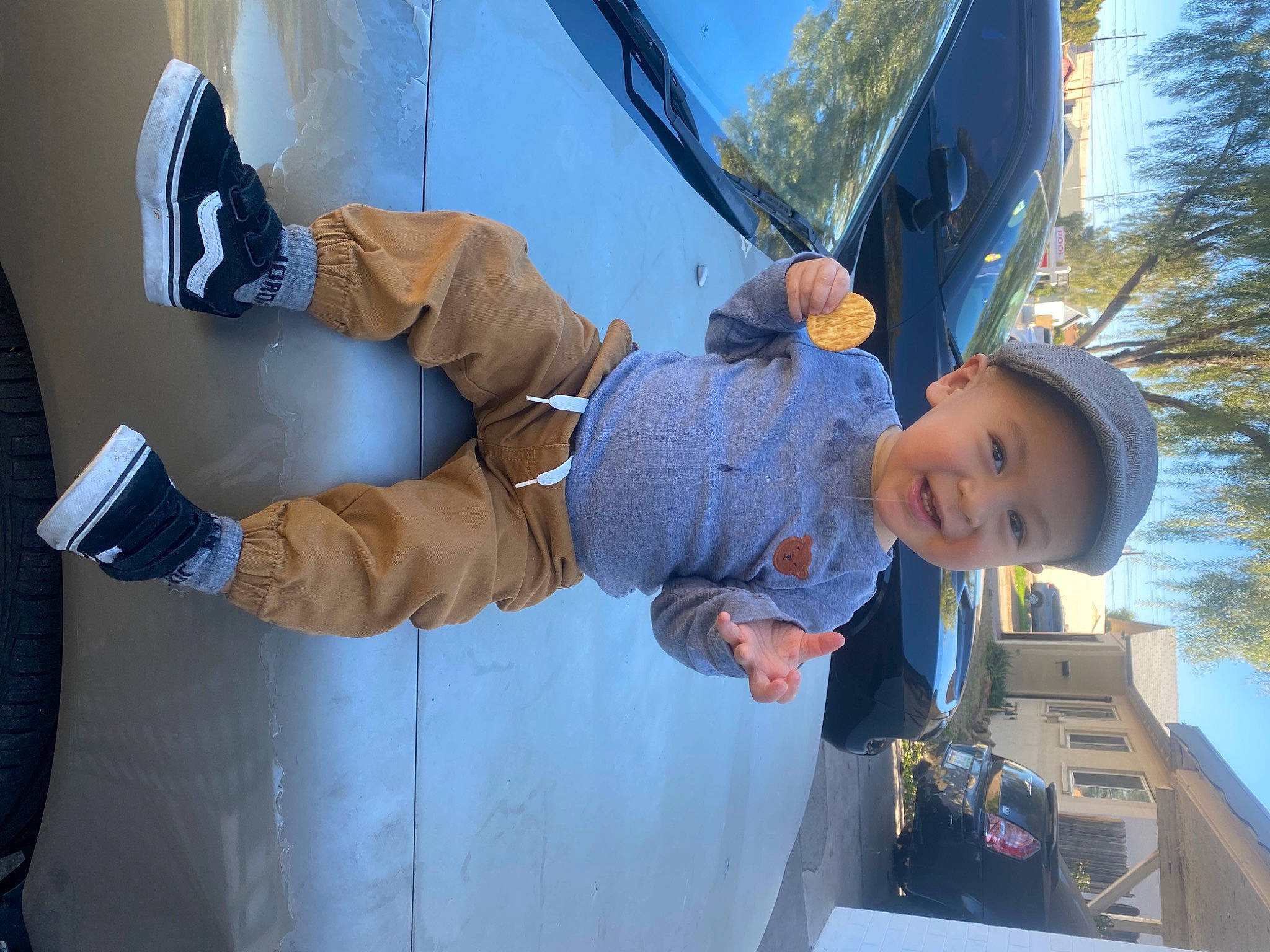 Nathaniel is registered to the contest to win money with this photo: baseball_cap, child, denim, electric_blue, fun, gesture, glove, headwear, helmet, leisure, person, personal_protective_equipment, plant, recreation, sky, sports_gear, toddler, travel, tree, vehicle_door