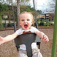 Ryan is registered to the contest to win money with this photo: baby, child, clothing, daylight, fun, happy, metal_chains, mulch, nature, outdoor, pants, park, person, play, playground, shirt, smiling, swing, toddler, trees