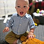 baby, child, indoor, smiling, happy, blue_shirt, striped, khaki_pants, stuffed_animal, plush_toy, sitting, floor, playful, cute, infant, portrait, hand, sock, expression, toy