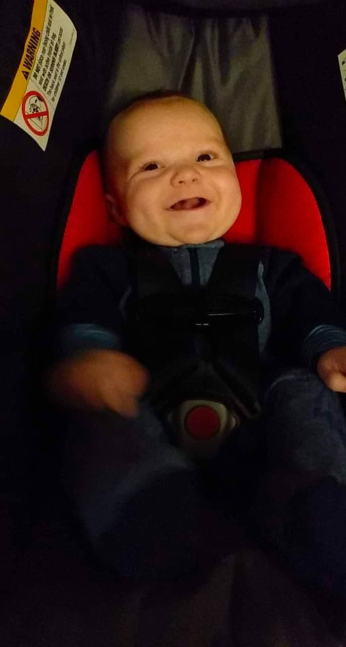 Bryant is registered to the contest to win money with this photo: baby, baby_carriage, car_seat, cheek, child, eye, face, facial_expression, happy, head, laugh, nose, person, product, red, skin, smile, toddler