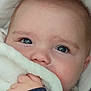 baby, blanket, blue_eyes, child, close_up, comfort, cozy, cute, expression, eyelashes, face, hand, hooded_clothing, indoor, infant, portrait, skin, soft_texture, warm, young