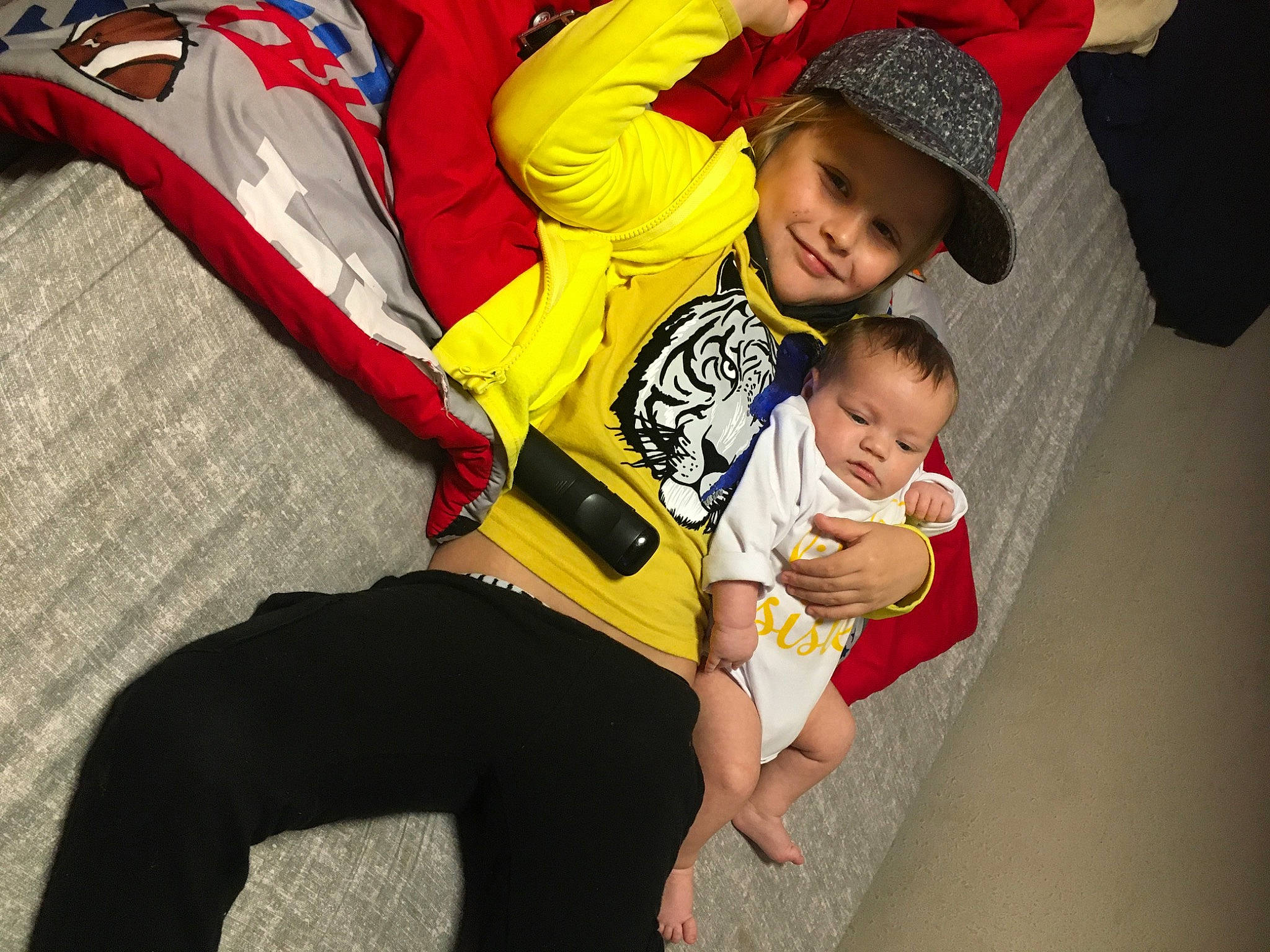 Ryder is registered to the contest to win money with this photo: abdomen, baby, baby_carriage, baby_products, baby_toddler_clothing, child, comfort, event, foot, fun, happy, headwear, joy, lap, leisure, luggage_and_bags, people, person, red, sitting