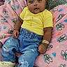 baby, bracelets, cartoon_characters, child, comfortable, cute, denim_jeans, fashion, hair_bows, happy, indoors, infant, necklace, pink_blanket, portrait, sitting, slippers, smiling, soft_blanket, yellow_shirt