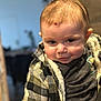 baby, candid, checkered_clothing, cheeky, child, closeup, clothing, cute, expression, face, head, human, indoor, infant, jacket, person, portrait, smile, warm_lighting, young