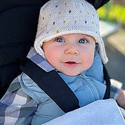 Mayron a rejoint le concours — aidez-le/la à gagner de superbes lots ! baby, blanket, blue_eyes, child, cozy, cute, face, infant, jacket, knitted_hat, outdoor, plaid_shirt, pom_pom, portrait, smile, soft_lighting, straps, stroller, warm_clothing, young_child