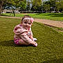 Evelynn joined the competition — help win amazing prizes! baby, child, girl, smiling, sitting, grass, park, outdoor, hoodie, headband, flower, nature, trees, path, daylight, cute, happy, infant, green, sky