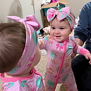 Evelynn joined the competition — help win amazing prizes! baby, child, mirror, reflection, pink, headband, pajamas, smiling, indoor, carpet, person, face, hand, toy, home, furniture, adult, support, cute, happy