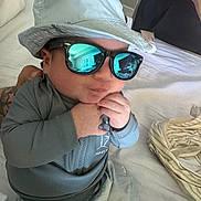Eric joined the competition — help win amazing prizes! baby, hat, sunglasses, bed, hand, clothing, indoor, reflection, person, infant, cute, fashion, accessory, portrait, human, child, bedroom, casual, young, cool