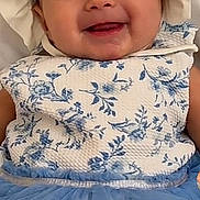 Mía is registered to the contest to win money with this photo: baby, child, infant, smiling, portrait, bonnet, dress, floral_pattern, blue_clothing, sitting, indoors, happy, face, eyes, mouth, fashion, baby_clothing, headwear, close_up, photography