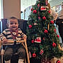 Saad joined the competition — help win amazing prizes! toddler, child, high_chair, christmas_tree, christmas_decorations, red_baubles, gift_box, indoor, cafe, striped_sweater, bib, wooden_furniture, floor_tiles, smiling, holiday, festive, people, woman, glasses, sign