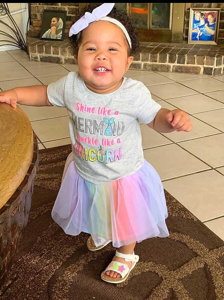 La Niya is registered to the contest to win money with this photo: baby_toddler_clothing, baseball_cap, beauty, blurred, cap, child, flip_flops, fun, happy, hat, joy, leisure, magenta, person, pink, sandal, skin, sleeve, smile, standing