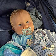 Amaël a rejoint le concours — aidez-le/la à gagner de superbes lots ! baby, baby_bib, blanket, blue_eyes, child, childcare, closeup, clothing, comfort, cute, face, indoors, infant, pacifier, portrait, resting, soft_toy, stroller, wrapped, young_child