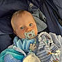 baby, baby_bib, blanket, blue_eyes, child, childcare, closeup, clothing, comfort, cute, face, indoors, infant, pacifier, portrait, resting, soft_toy, stroller, wrapped, young_child