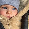 baby, child, face, blue_eyes, beanie, winter_clothing, coat, zipper, fur, bundle, warm, rosy_cheeks, closeup, portrait, infant, soft_texture, glove, snug, thoughtful, outdoor_gear